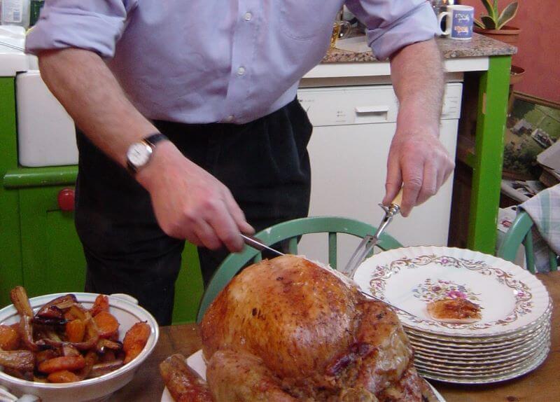 Father cutting roasty turkey