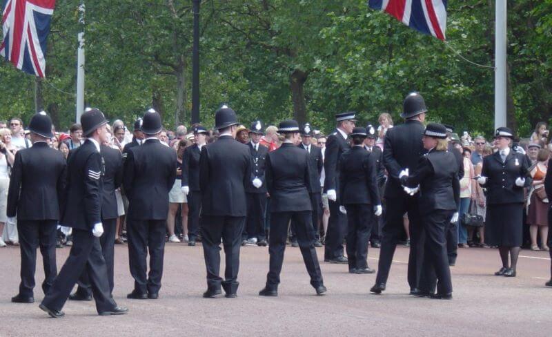 police officers leading tourists to Buckingham Palace