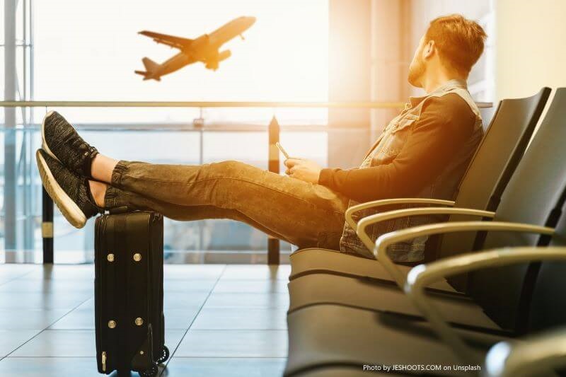 a man sitting chair and looking at an airplane