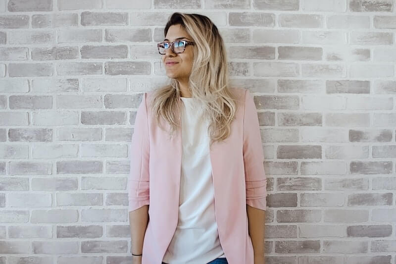 a woman wears a pink cardigan